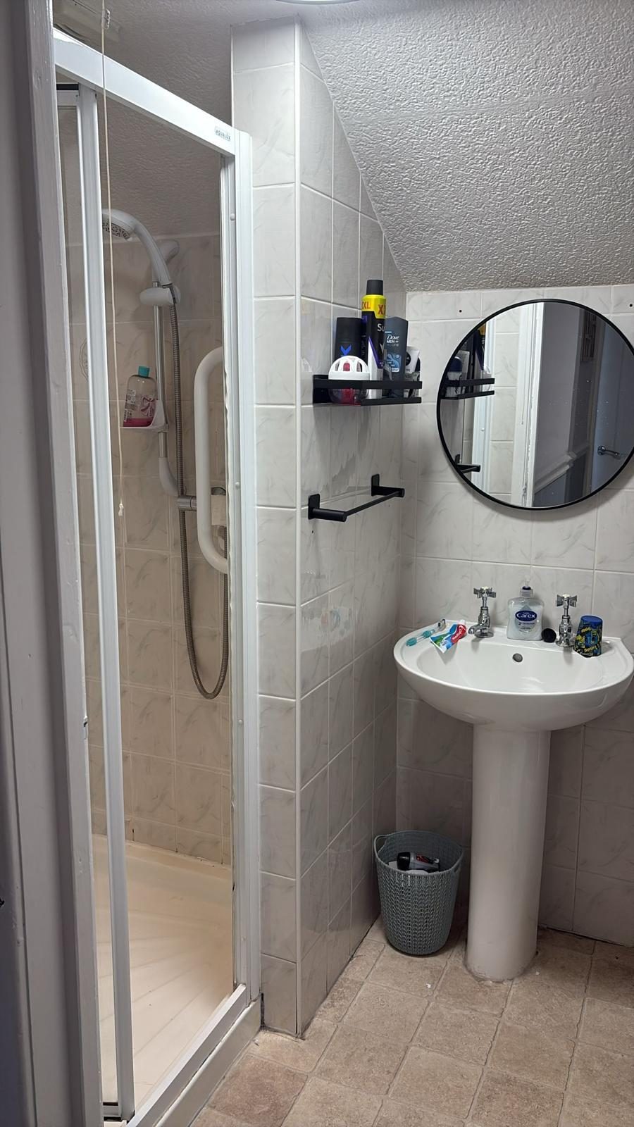 Existing bathroom with shower enclosure and pedestal basin before refurbishment