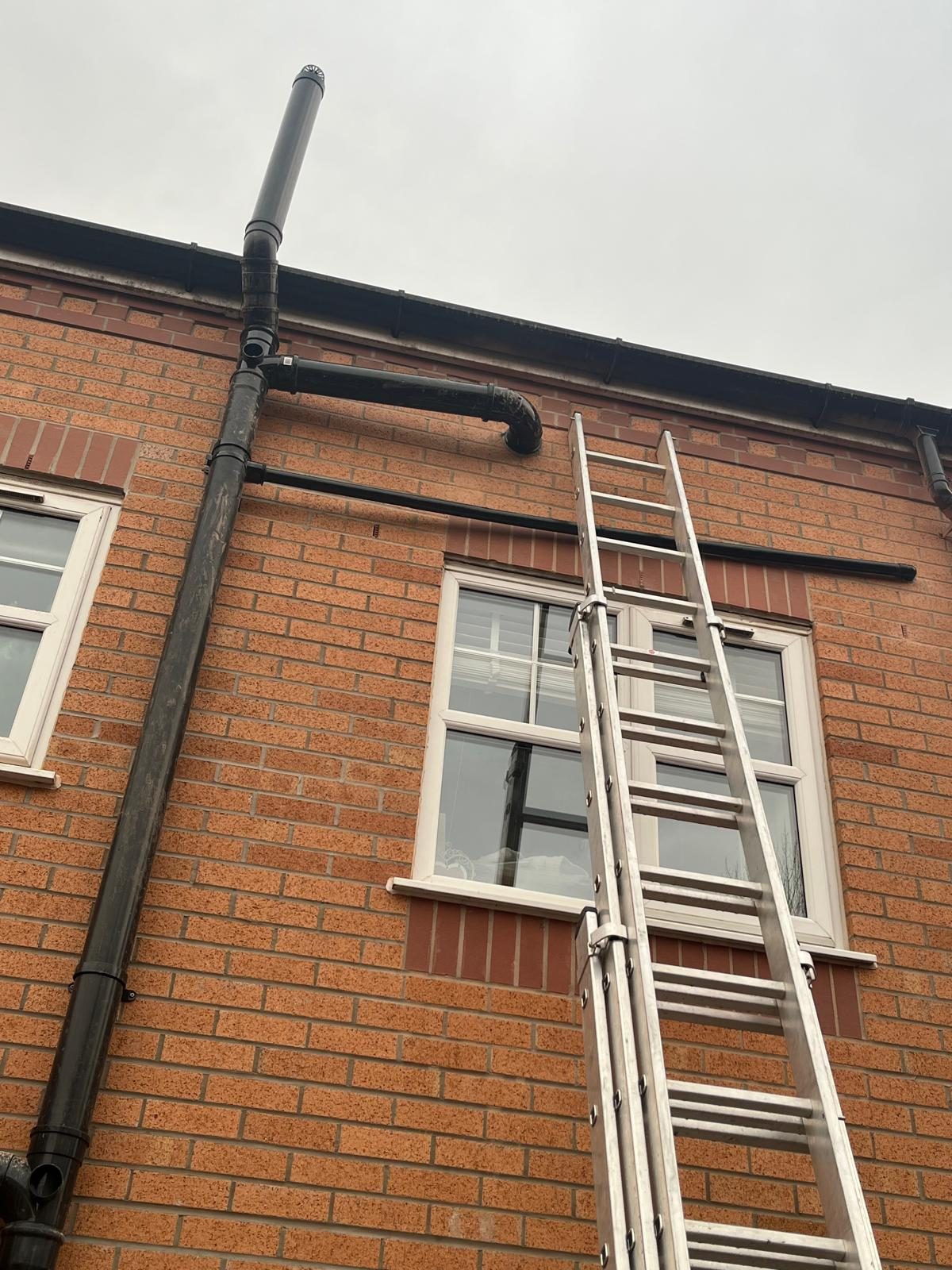External soil pipe and vent terminal on a brick property inspected during plumbing work