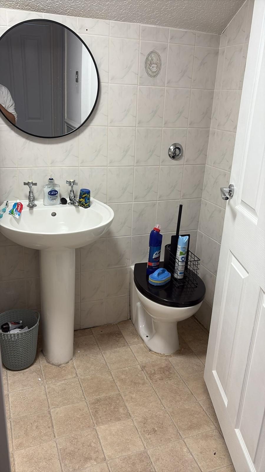 Older tiled bathroom with pedestal basin and toilet prior to a full bathroom renovation