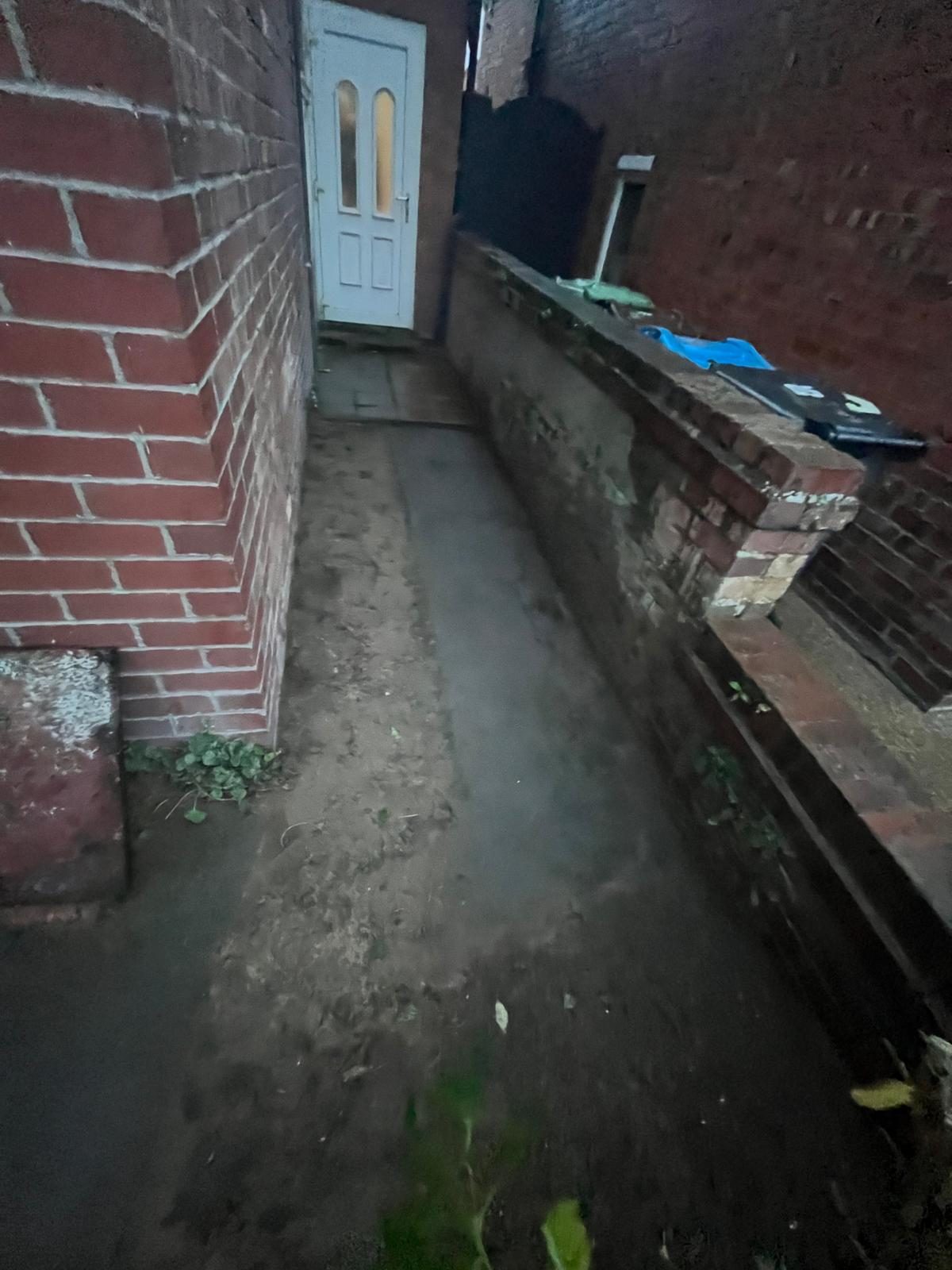 Rear yard drainage and external pipework at a terraced property before plumbing repairs