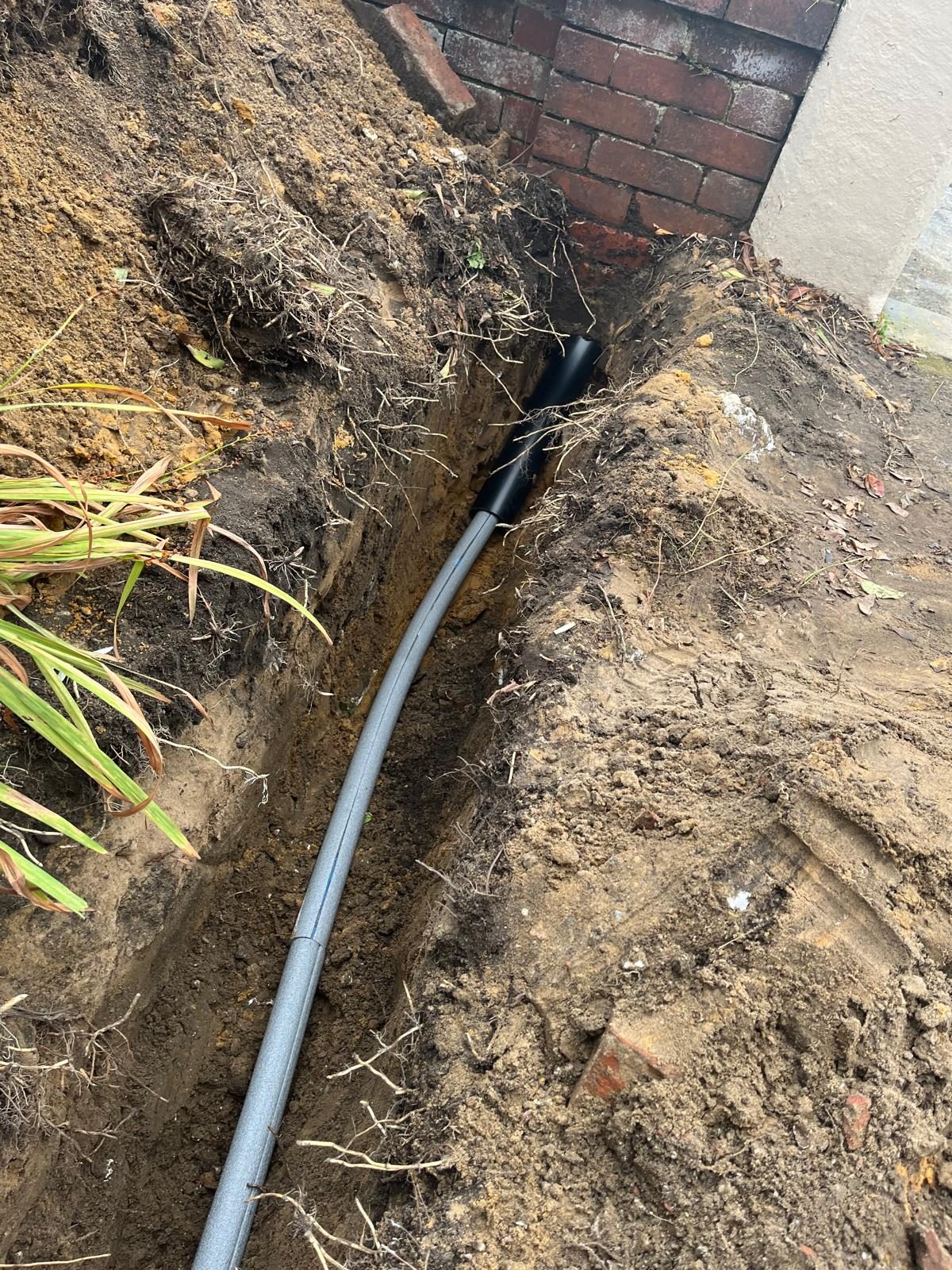 Replacement water supply pipe laid in a garden trench after leak repair