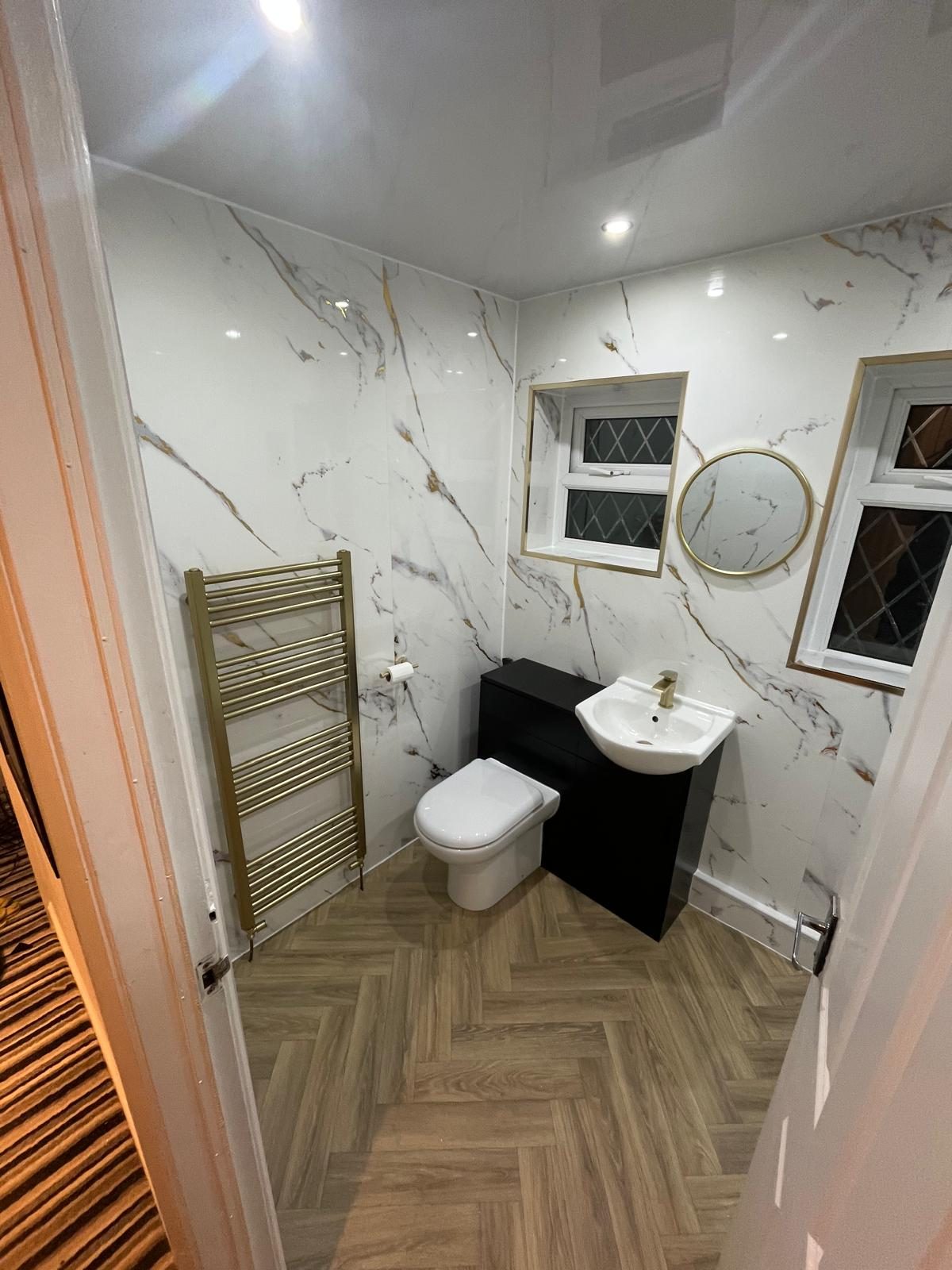 Finished WC with marble-effect panelling, black vanity unit and patterned floor tiles