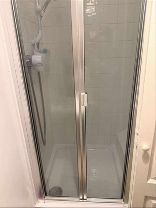 Existing bi-fold shower enclosure before replacement