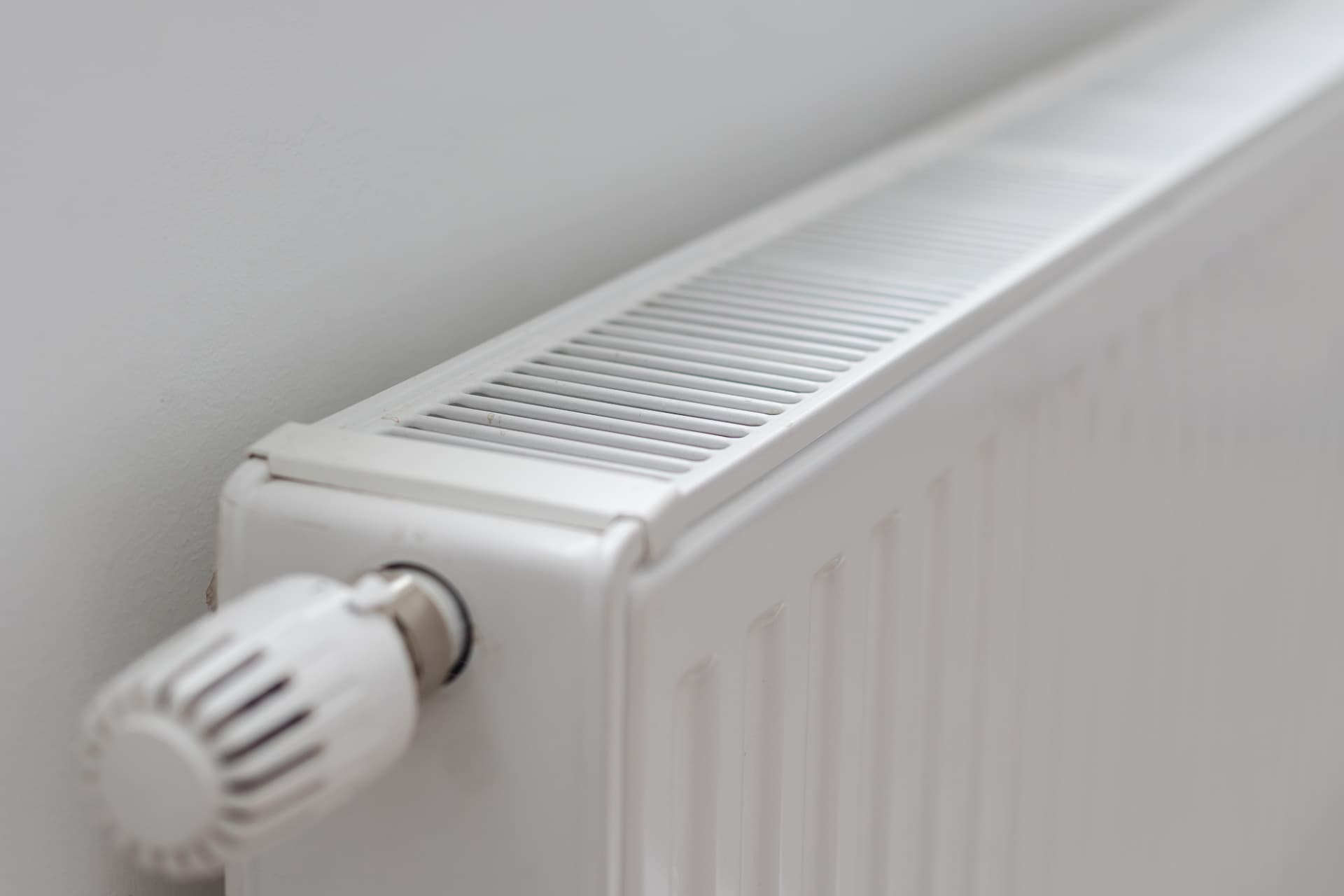 White panel radiator fitted to a wall with a thermostatic radiator valve after installation
